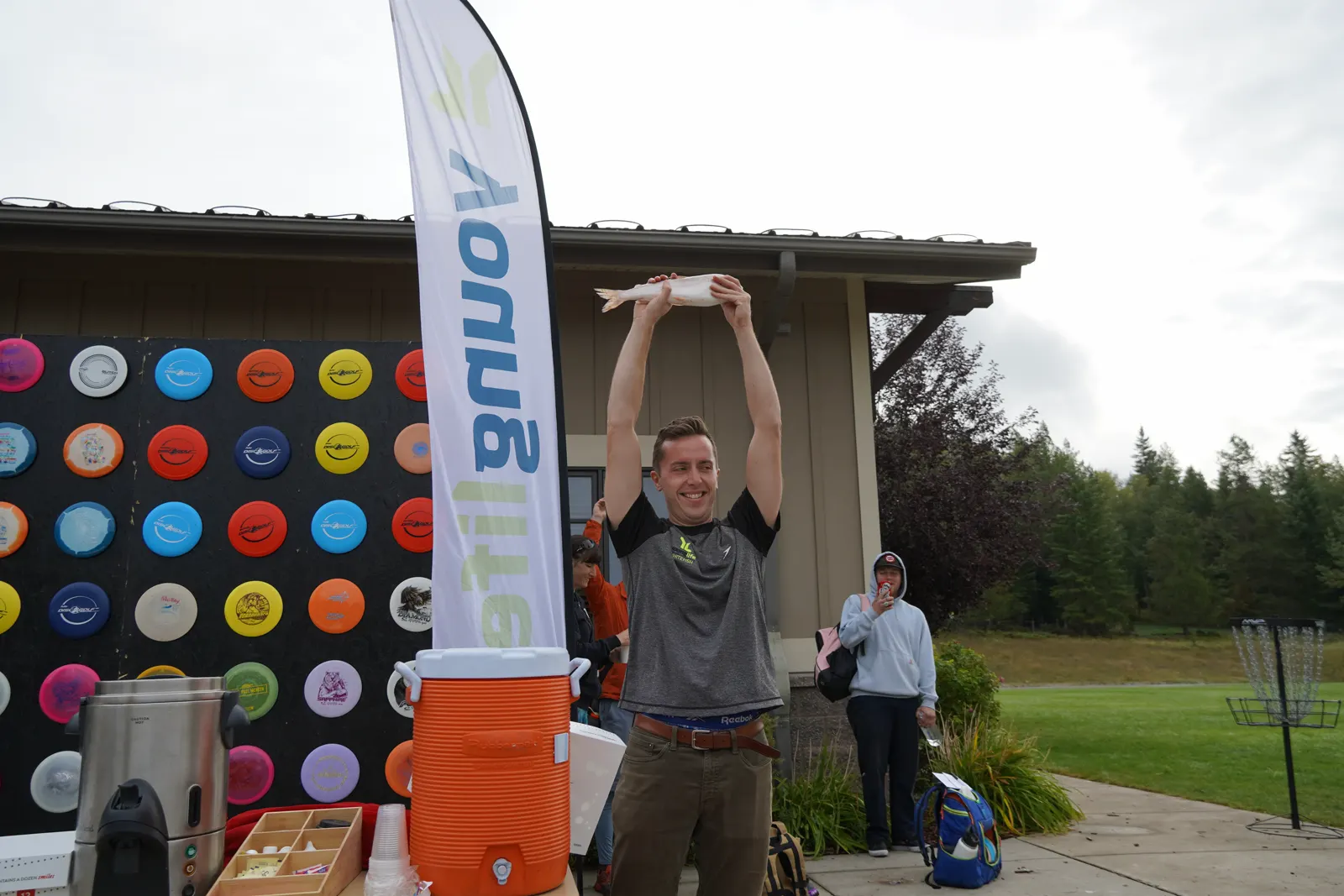 A participant holds a whitefish overhead before the ceremonial toss.